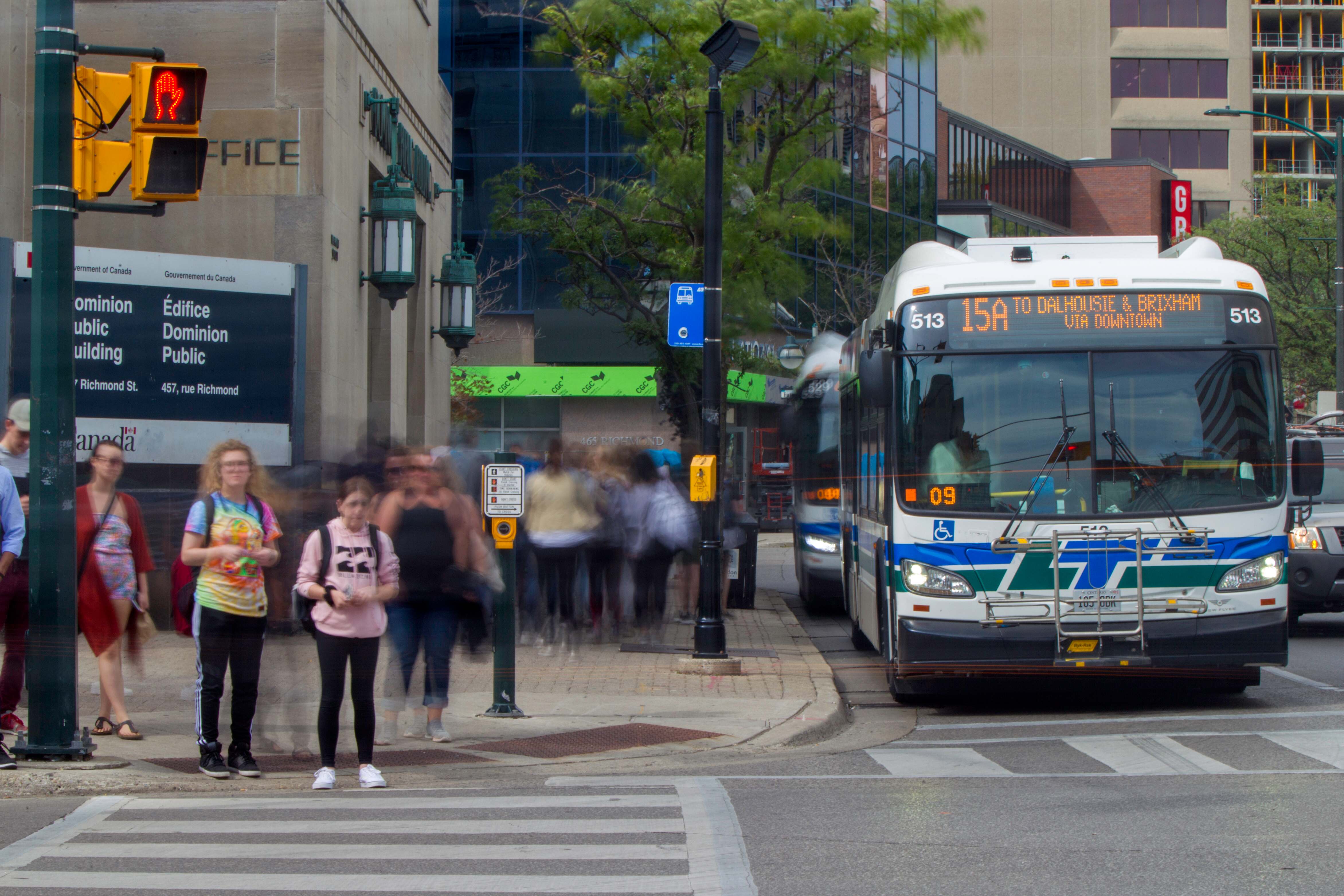 a bus and pedestrians at a downtown intersection